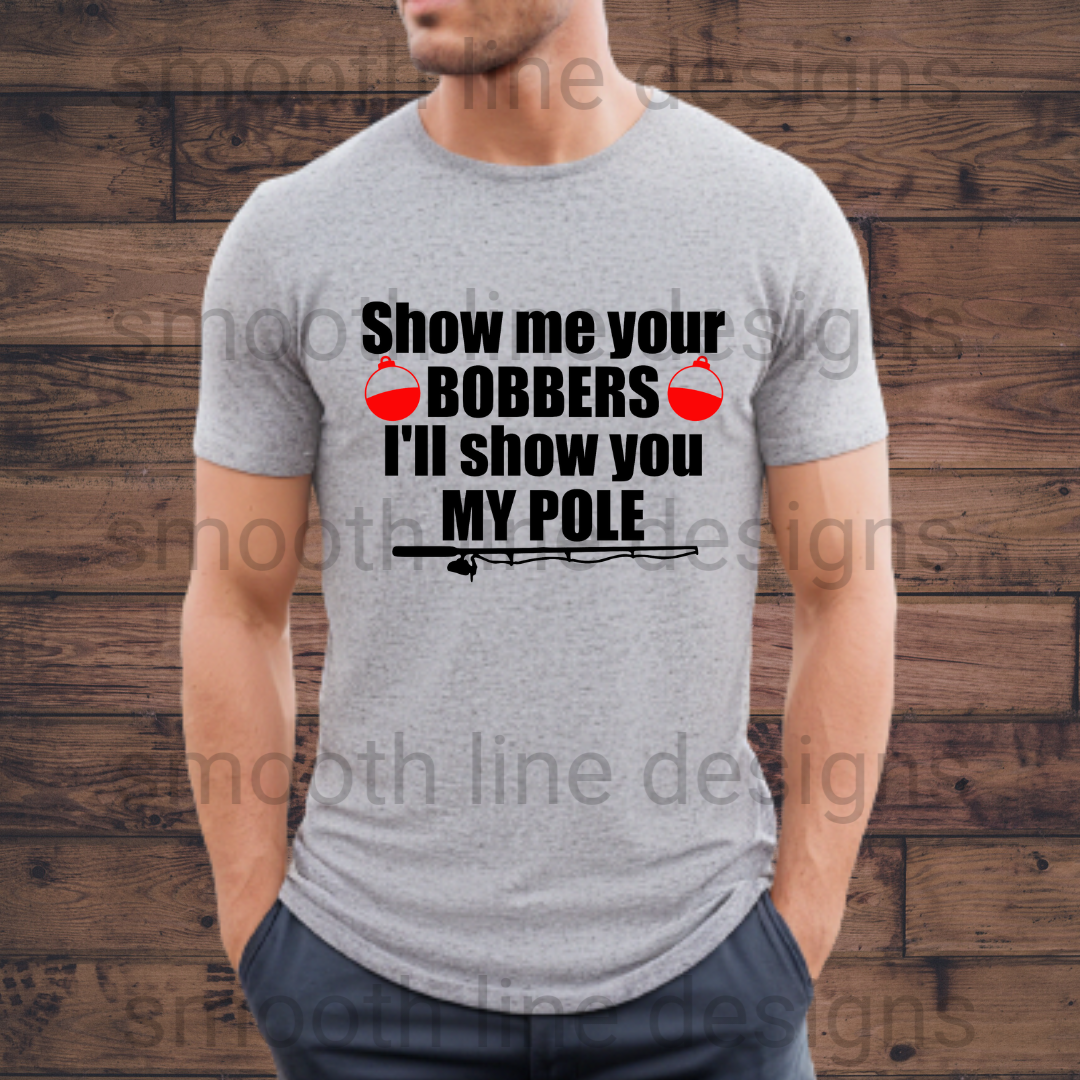 Reel in the laughs with this "Show Me Your Bobbers I’ll Show You My Pole" t-shirt! This hilarious fishing shirt is perfect for men who love to fish and appreciate a good joke 