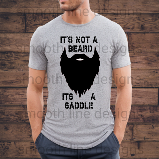 Show off your beard with pride in this "It’s Not a Beard, It’s a Saddle" t-shirt! Perfect for guys who love their facial hair, this funny beard shirt is made from soft, comfortable fabric, making it great for casual outings, hanging out with friends, or beard-related events.