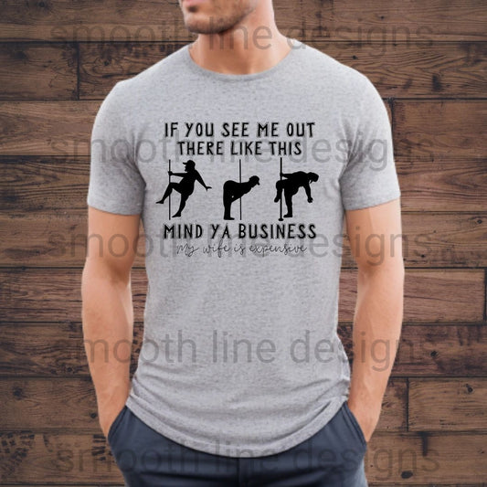 Get ready to share a laugh with this "Mind Ya Business My Wife Is Expensive" shirt! This funny men’s t-shirt is perfect for husbands who appreciate a good joke and want to show off their sense of humor.